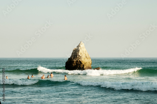 People bathing in sea and rock formation, Alvor, Algarve, Portugal photo