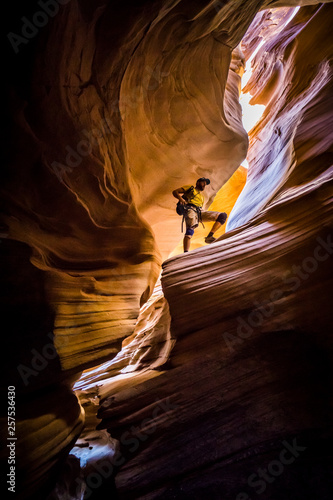 Man standing high up in a slot canyon in the desert. photo