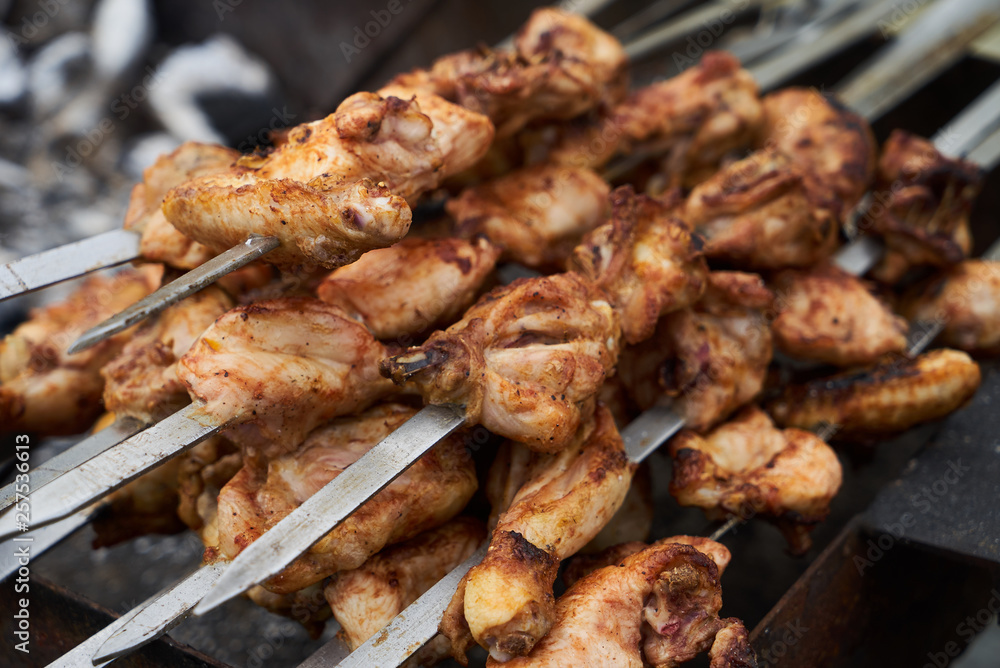 Roasted chicken wings meat kebab on skewers, close-up