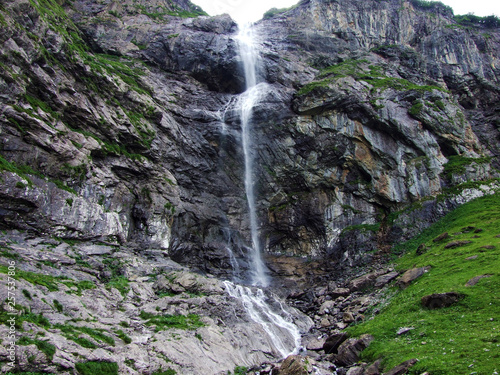 Waterfall Wannenbachfall in the alpine valley of Im Loch - Canton of Glarus, Switzerland photo