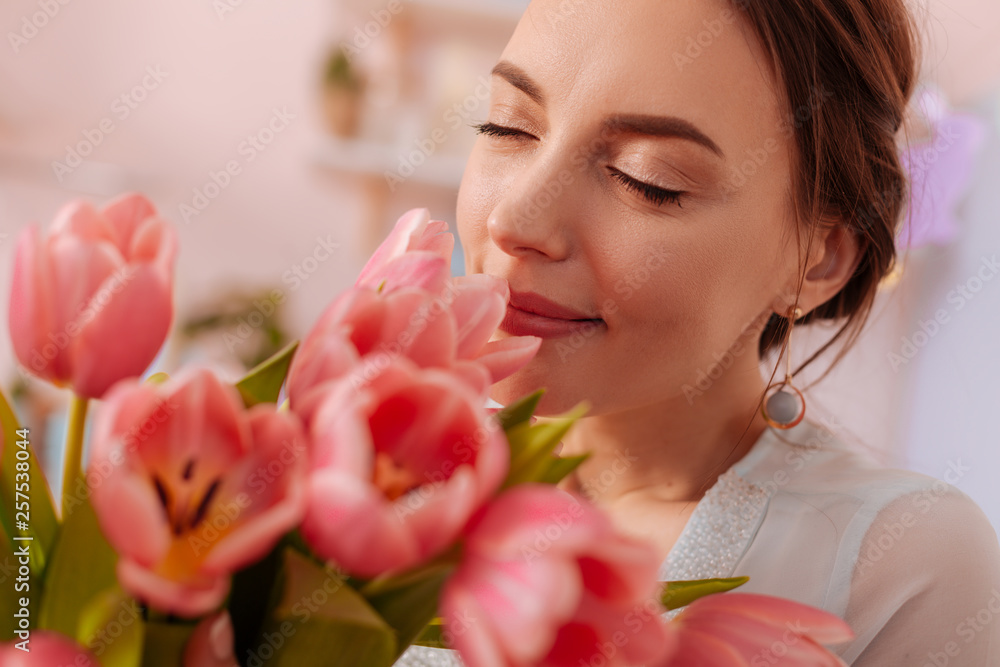 Portrait of cute woman that smelling tulips