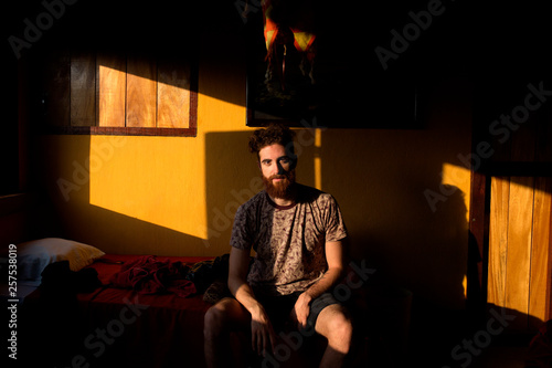 Man sitting in a room in morning light photo