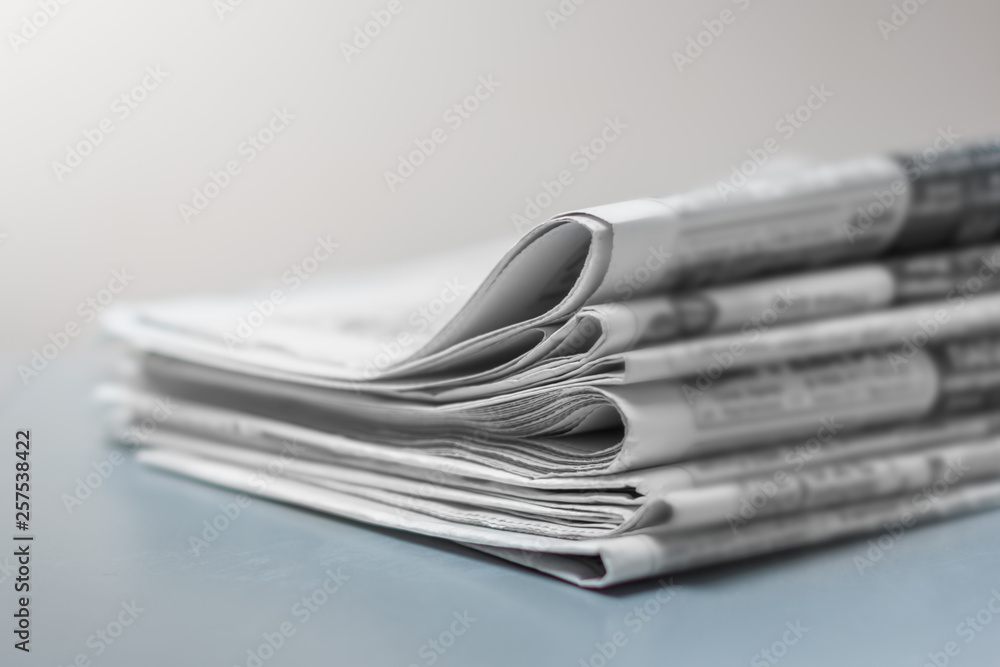 Pile of fresh morning newspapers on the table at office. Latest financial and business news in daily paper. Pages with information. Pile of fresh morning newspapers on the table at office. Latest financial and business news in daily paper. Pages with information.