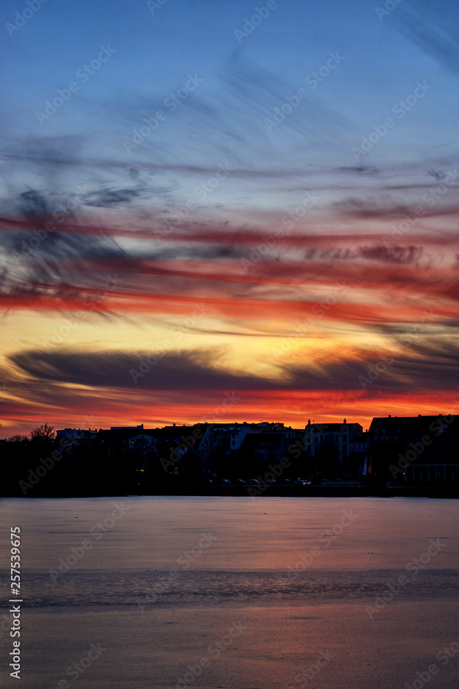 Sunset with dramatic clouds over a icy lake. Mecklenburg-Vorpommern, Germany