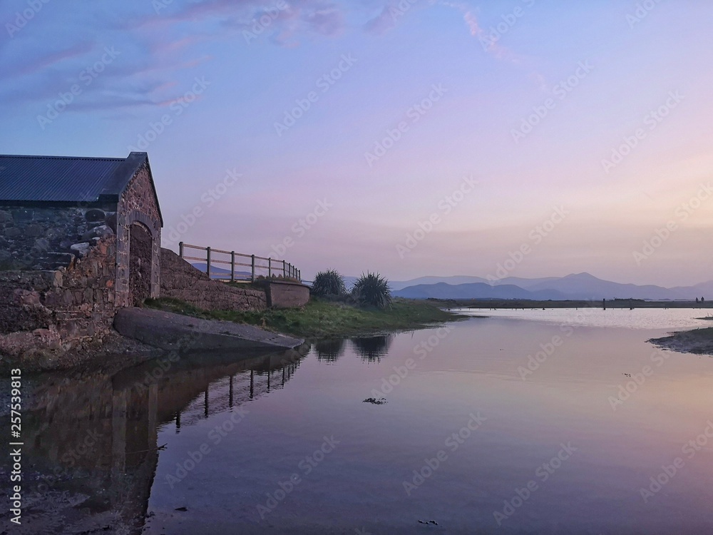 Scenic view of old irish house against purple sky 