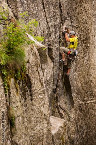 Man trad climbing a crack route in Esigo, Ossola, Italy. Ossola is one of the main destination in Europe for crack climbing. photo