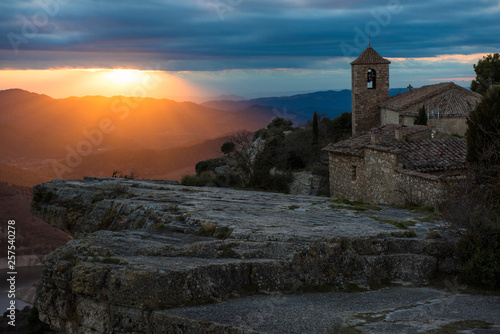 Sunrise over rocky ledge and stone church, Margalef, Catalunya, Spain photo