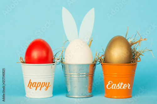 Easter eggs with Rabbit ears in colored buckets, selective focus image, Card Happy Easter
