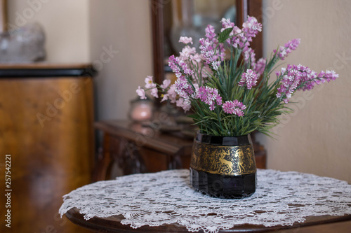 Piękne kwiaty w retro wazonie stojące na stole w starym wnętrzu, vintage 