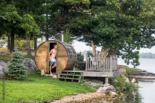 A man stands next to a backyard sauna along the St. Lawrence River in upstate New York's 1000 Islands.