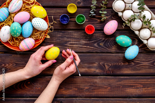 Colorful eggs for easter on wooden background top view