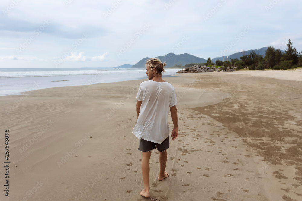 Rear view of man walking on beach