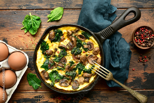 Omelette with mushrooms and spinach in a cast iron pan.Top view with copy space. photo