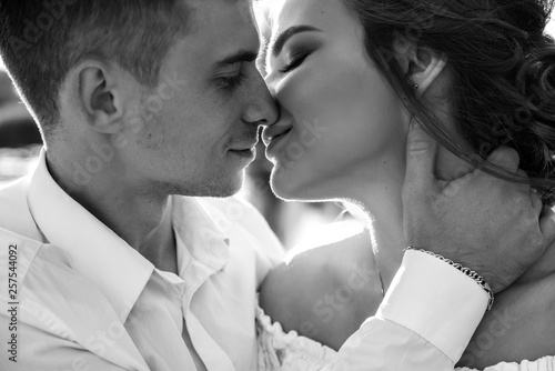 Young guy and girl gently kiss each other with love. Black and white photo