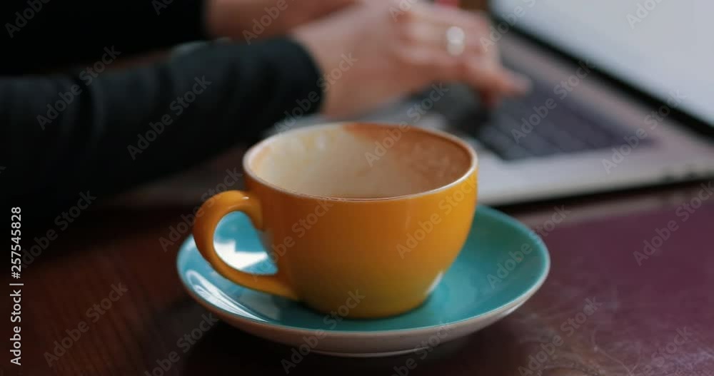 Woman hands working by laptop sitting in a cafe drinking coffee Woman hands working by laptop sitting in a cafe drinking coffee