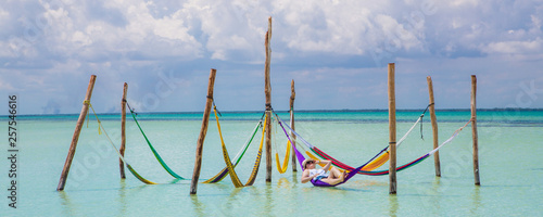 Woman restingCaribbean beach hammock photo