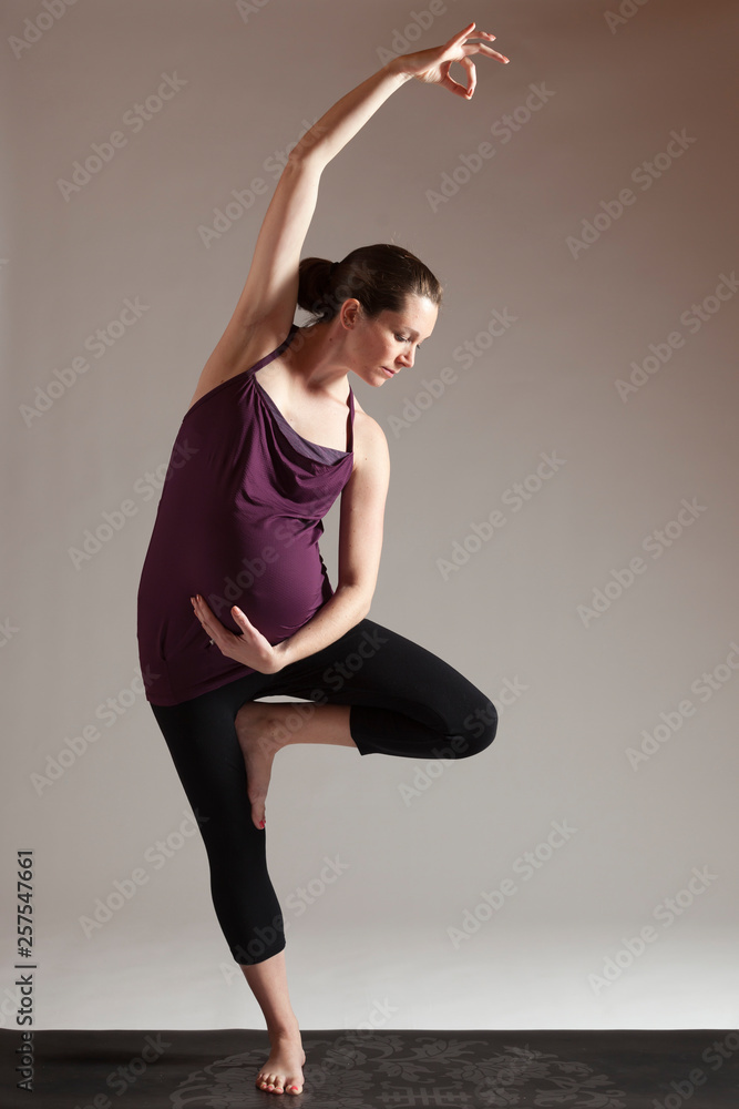 Pregnant woman practicing yoga against white background Pregnant woman practicing yoga against white background