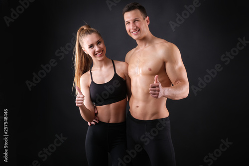 Fitness young man and woman isolated on black background.
