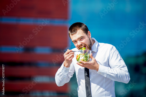 Young businessman in shirt and tie with salad lunch box