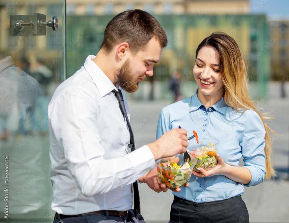 young businesswoman and businessman eating together salad young businesswoman and businessman eating together salad