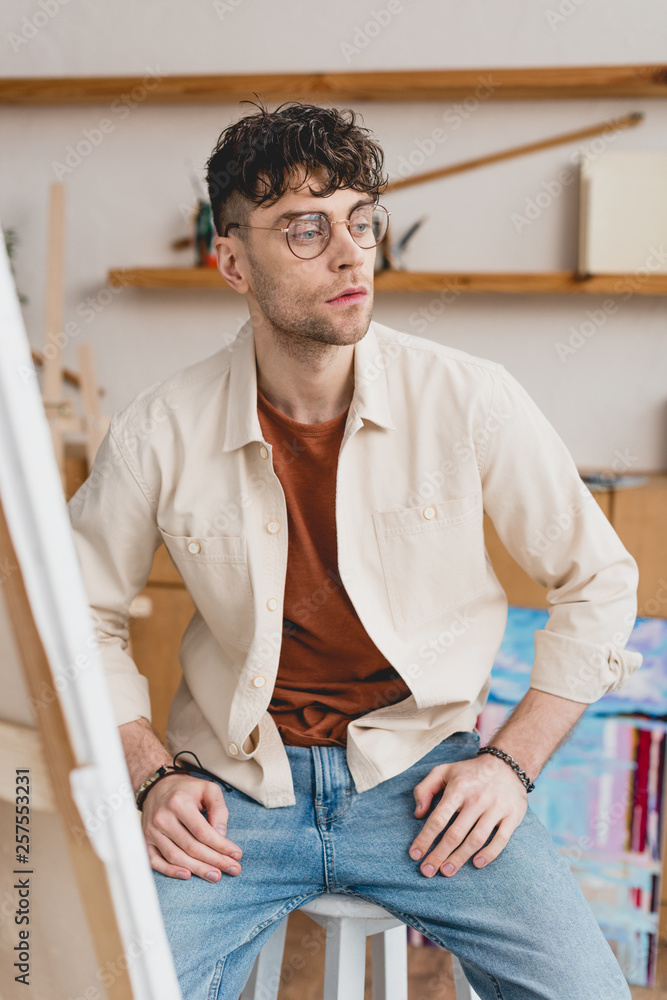 selective focus of serious artist in eyeglasses looking away selective focus of serious artist in eyeglasses looking away