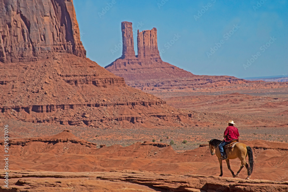 A Native American on horseback in a scenic view in Monument Valley. A Native American on horseback in a scenic view in Monument Valley.