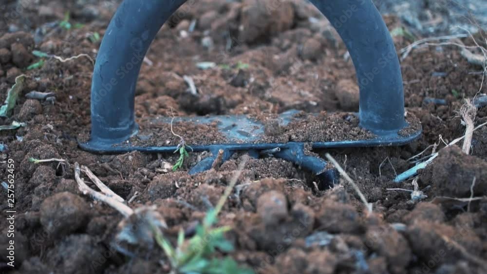 Tiller tines plunge into soil, twist, and pull out of ground, Slowmo Close Up Tiller tines plunge into soil, twist, and pull out of ground, Slowmo Close Up