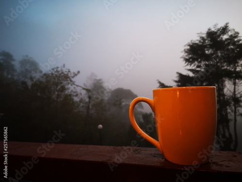 Drinking coffee outside corridor with beautiful foggy and misty around.