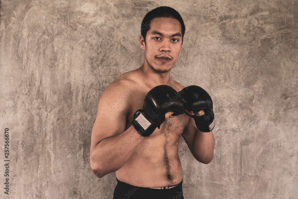 Portrait of  sportsman in boxing gloves on grunge background