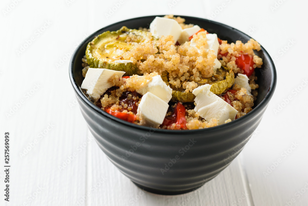 Salad of cheese, baked vegetables and boiled quinoa on a white table. Vegetarian dish. Salad of cheese, baked vegetables and boiled quinoa on a white table. Vegetarian dish.