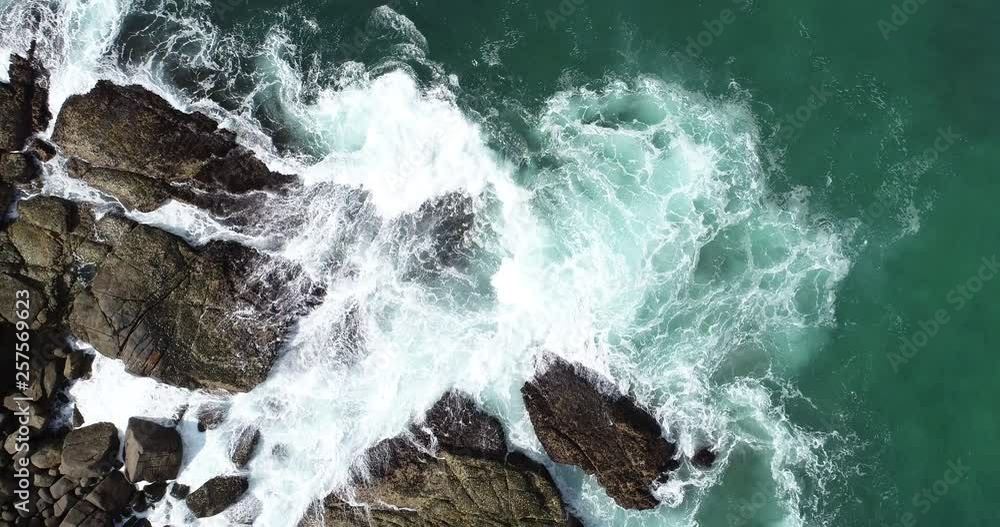 Top view water splashing on the rocky shore with splash drone 4k Top view water splashing on the rocky shore with splash drone 4k