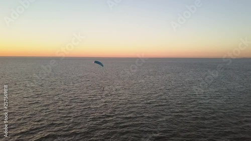 Kitesurfer using a hydrofoil during a sunset in Zeeland, the Netherlands.
