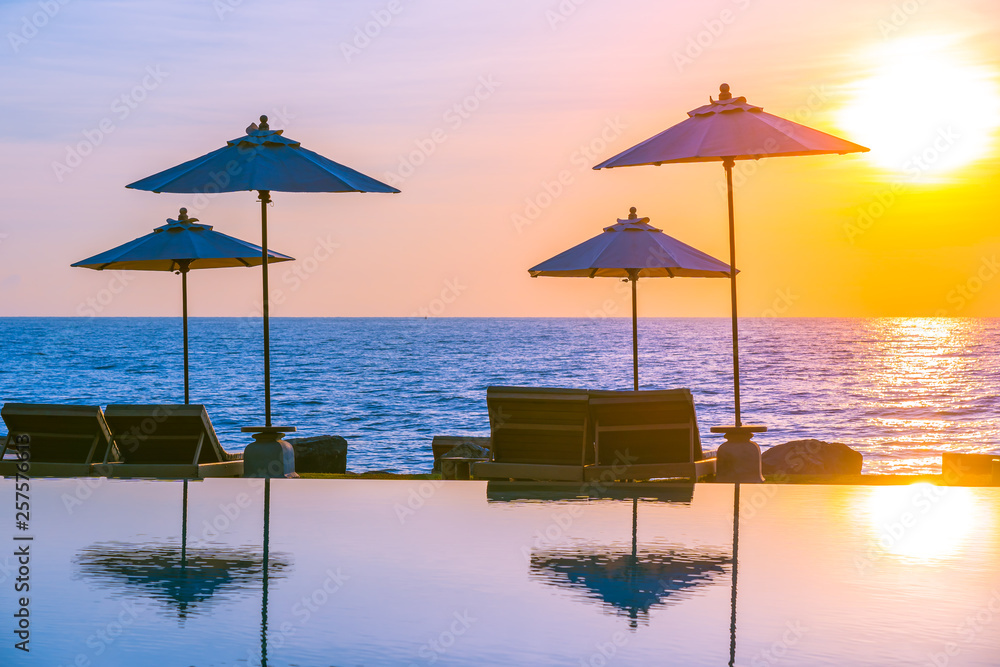 Umbrella and chair around swimming pool in resort hotel for leisure travel and vacation