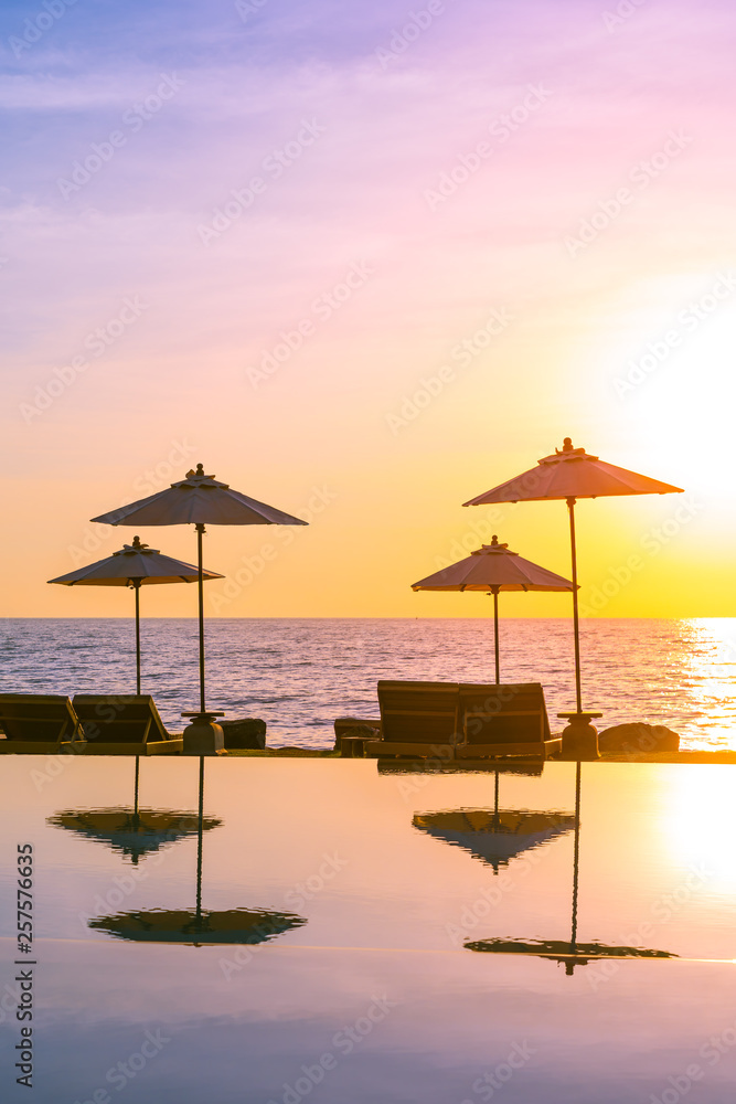 Umbrella and chair around swimming pool in resort hotel for leisure travel and vacation Umbrella and chair around swimming pool in resort hotel for leisure travel and vacation