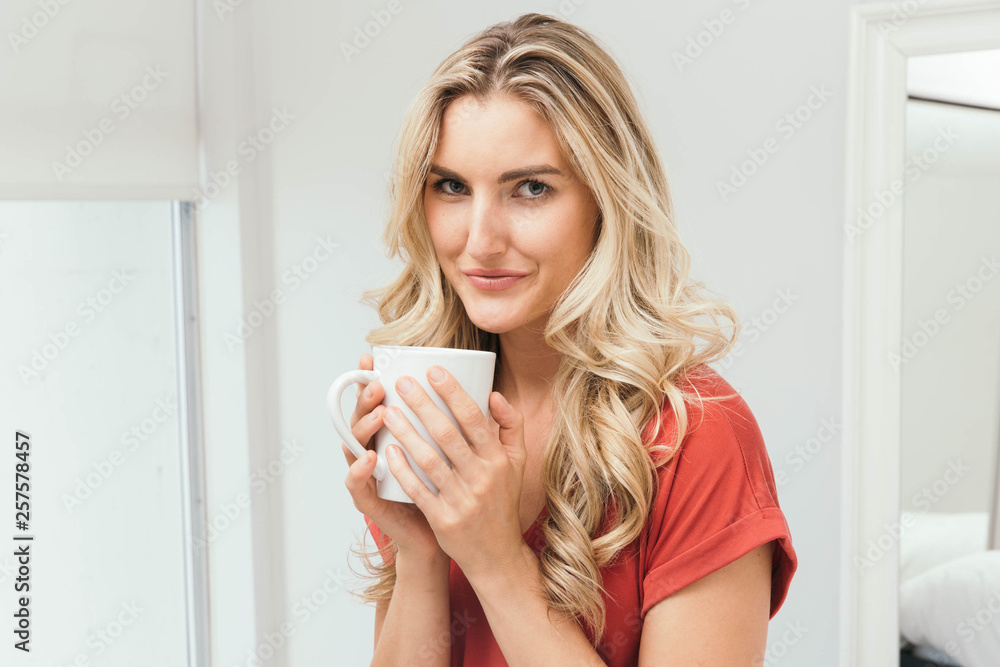 Blonde drinking coffee, tea or soup from a white cup Blonde drinking coffee, tea or soup from a white cup