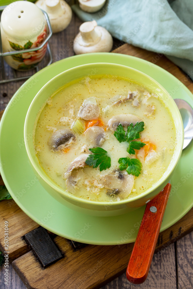 Cream soup with cream, chicken and mushrooms on a rustic-style kitchen table. Copy space.