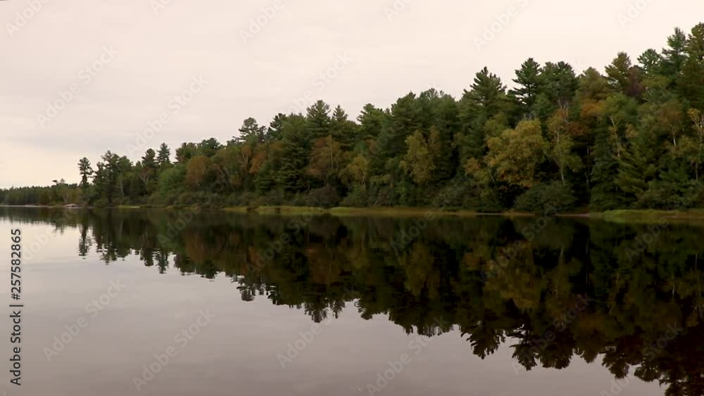 Fall foliage on a calm lake panning right to left Fall foliage on a calm lake panning right to left