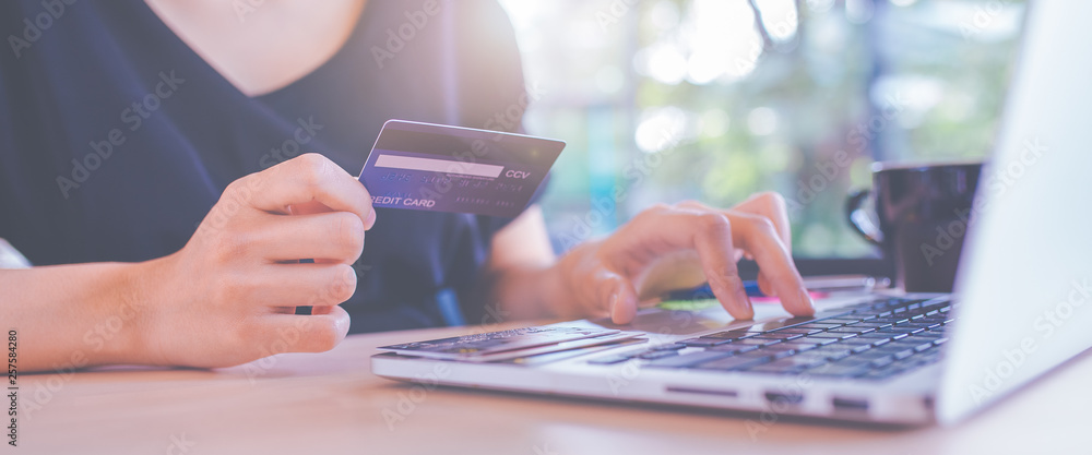 Business women hand use credit cards and laptop computers to shop online.