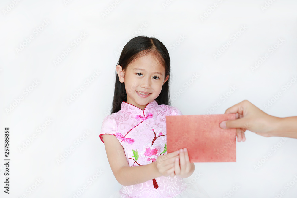 Happy little Asian child girl wearing pink traditional cheongsam dress smiling while receiving Chinese New Year red envelope packet isolated on white background. Happy chinese new year concept. Happy little Asian child girl wearing pink traditional cheongsam dress smiling while receiving Chinese New Year red envelope packet isolated on white background. Happy chinese new year concept.