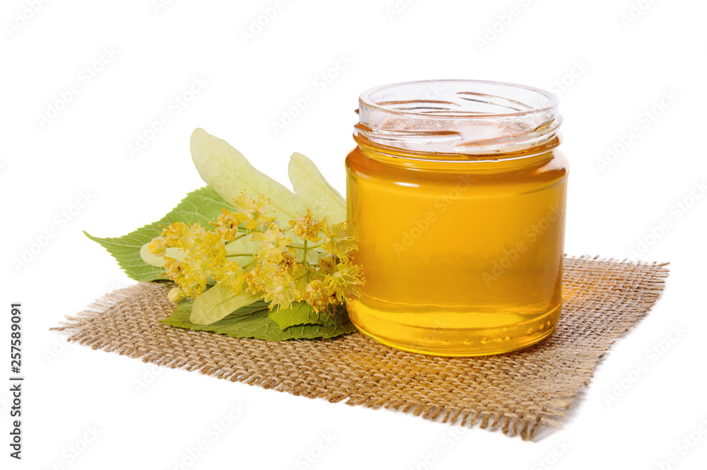 Open jar of linden honey and lime flowers isolated on white background. Open jar of linden honey and lime flowers isolated on white background.