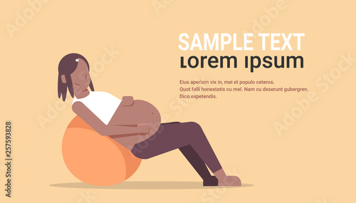 pregnant woman sitting on gymnastic ball african american girl exercises with fitball working out fitness pregnancy healthy lifestyle concept full length horizontal copy space