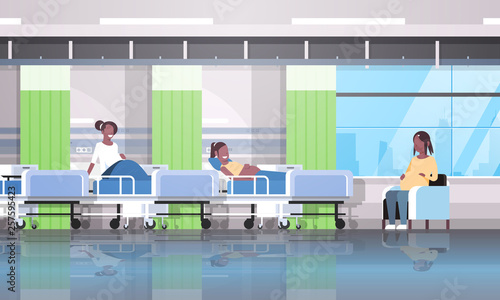 african american pregnant women patients sitting in bed and armchair girls discussing communication pregnancy and motherhood concept modern clinic ward interior flat horizontal