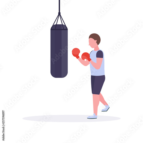 man boxer doing exercises with punching bag making direct hit in red boxing gloves guy fighter training workout healthy lifestyle concept flat white background