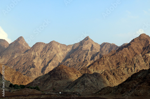 Geological landscape of hatta dam characterised by dry and rocky mountains and lake between scenery mountains  water reservoir Between hills in Dubai  United Arab Emirates