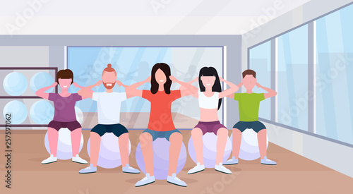 people group sitting on fitness ball men women doing press exercises training in gym aerobic workout healthy lifestyle concept modern health club studio interior horizontal