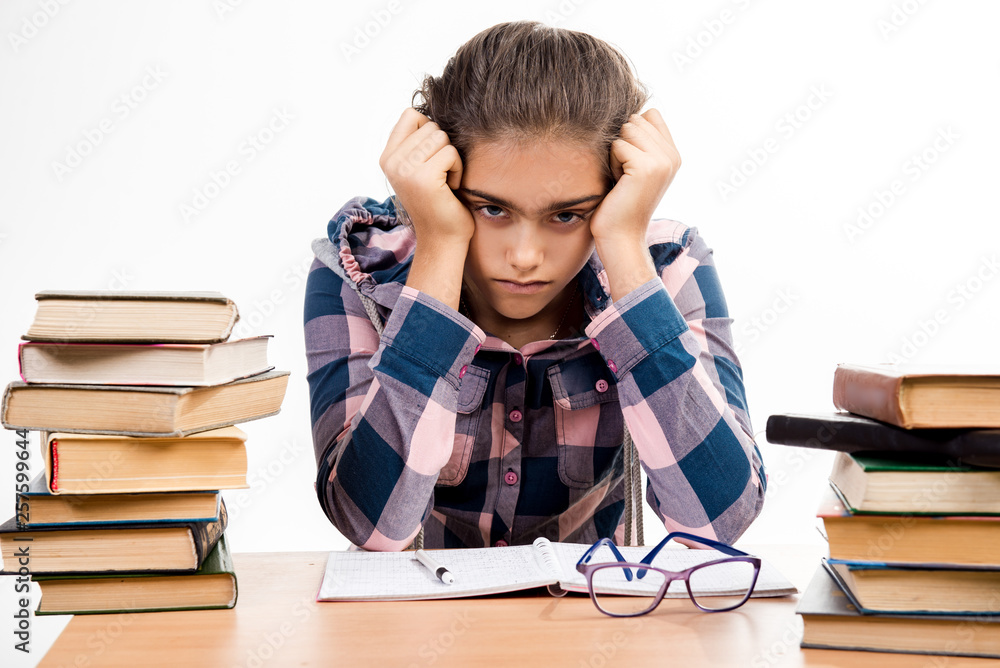 Girl with books. student is sitting at the table with books. Examinations at school. Graduation from college. Tired of learning Girl with books. student is sitting at the table with books. Examinations at school. Graduation from college. Tired of learning