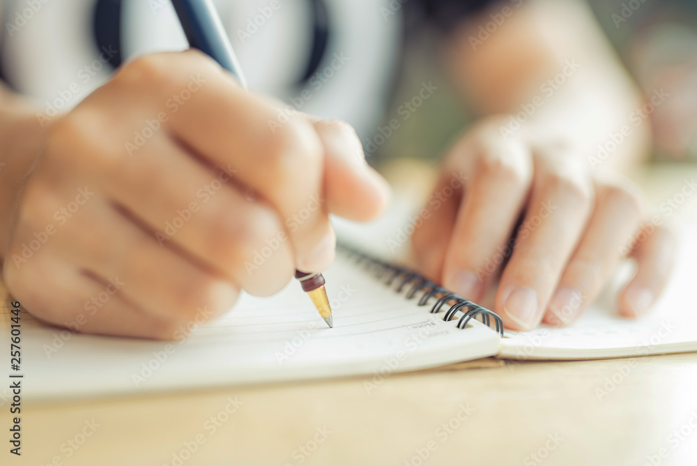 Fototapeta premium female hands with pen writing on notebook - Image