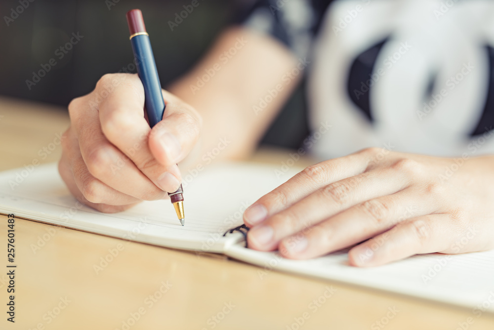 female hands with pen writing on notebook - Image female hands with pen writing on notebook - Image