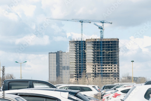 Modern building under construction, parking in the foreground