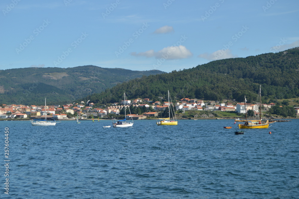 Boats Moored Along With Mussel Breeders In The Estuary Of The Muros Village. Nature, Architecture, History, Street Photography. August 19, 2014. Muros, Pontevedra, Galicia, Spain.